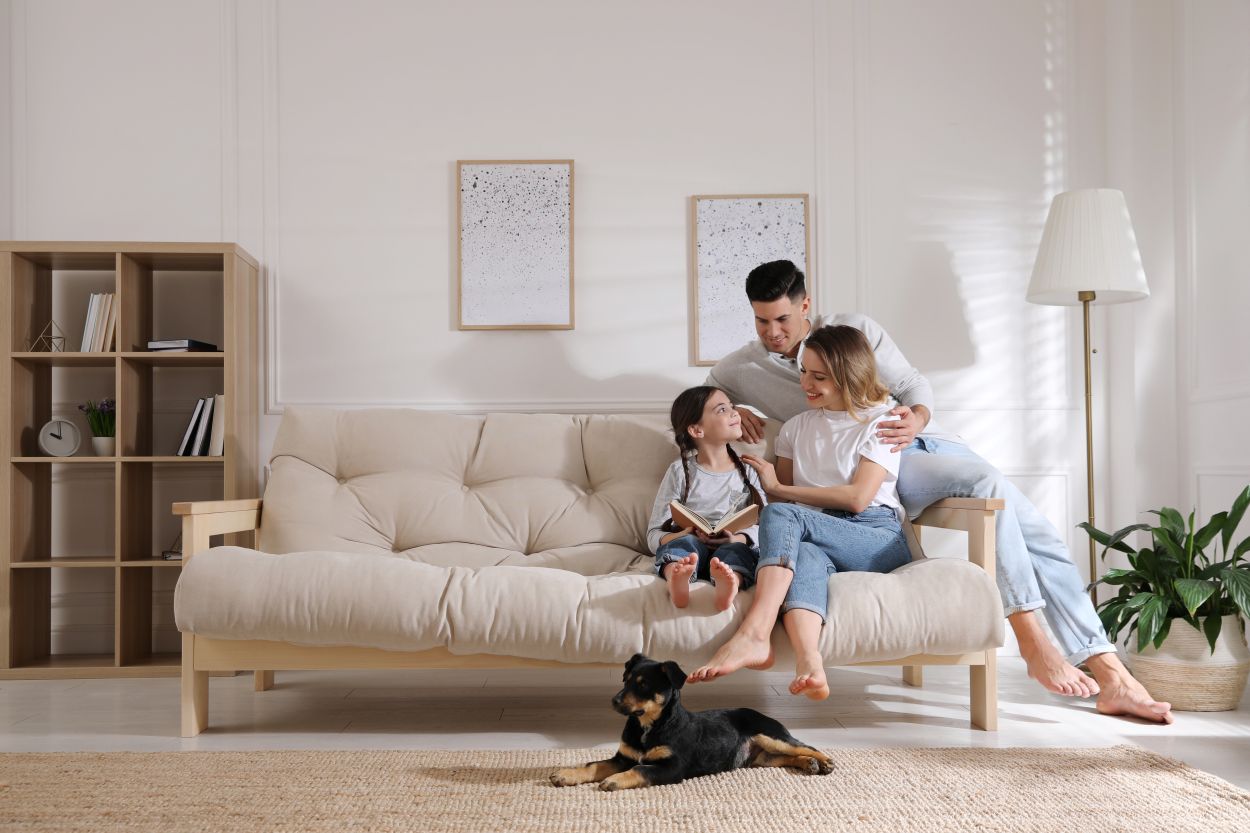 young family sitting together on sofa with dog in clean quality air